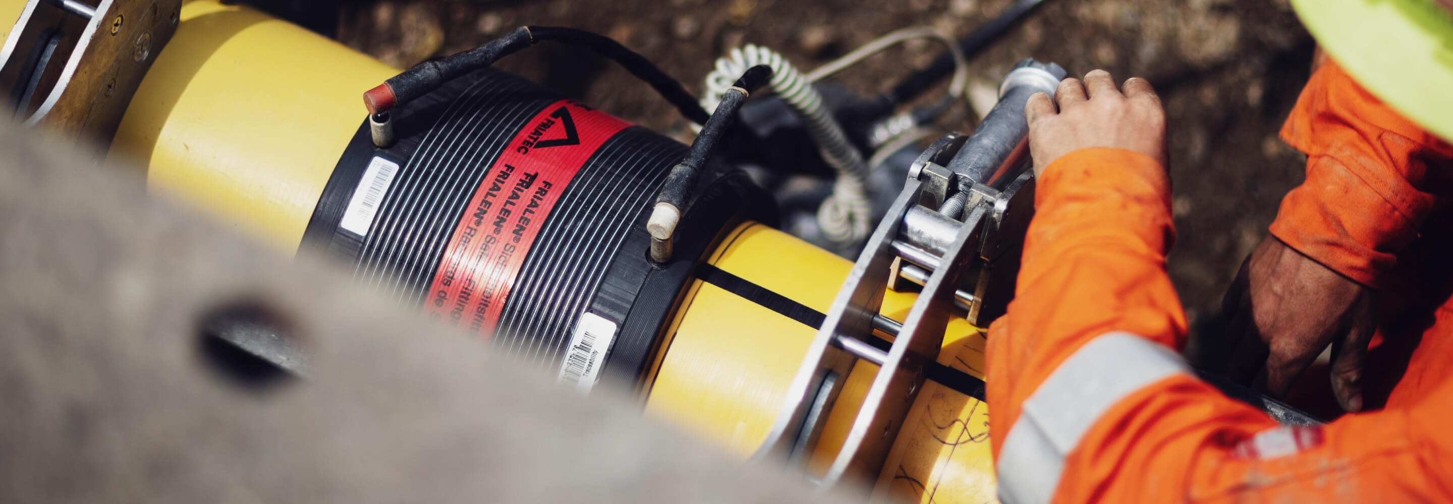 Employee in safety gear working on a piece of equipment