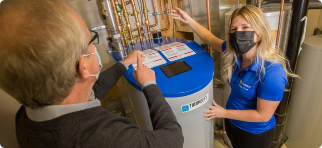 Woman and man standing near a heat pump