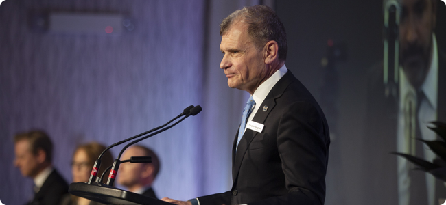 A man standing at a mic and podium 