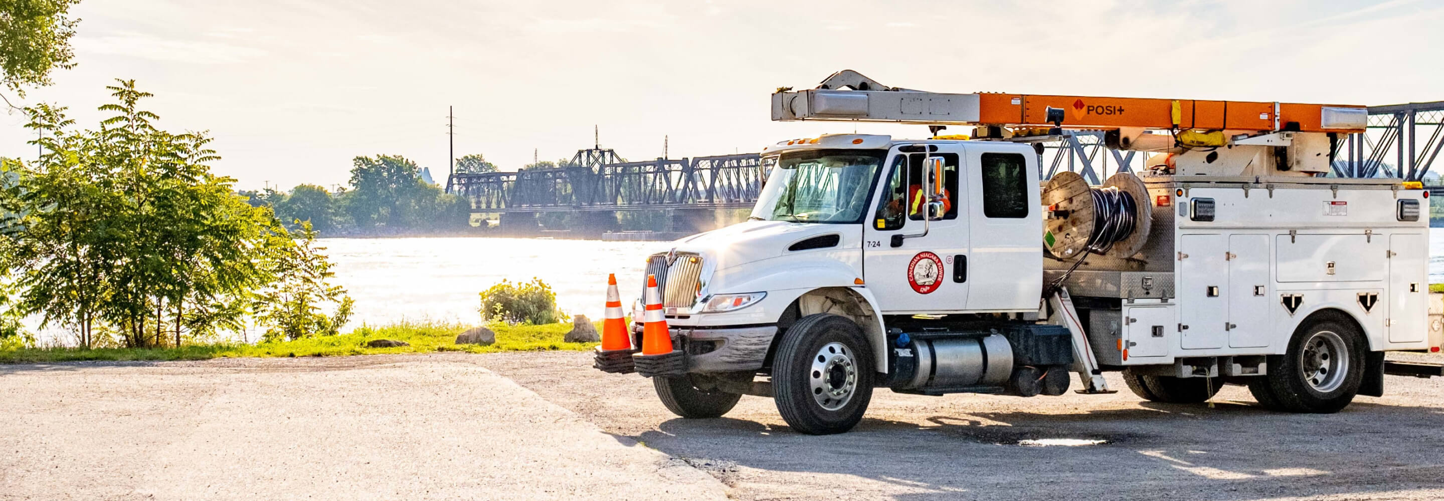 A bucket truck by a body of water