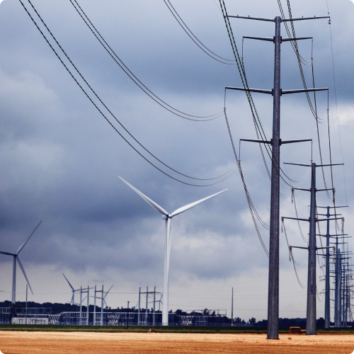 Several transmission towers, power lines, and wind turbines